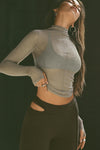 Front view of model posing in the fitted and sheer dew mesh Exposed Seams Long Sleeve top with a mock neckline and exposed seam details