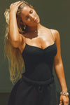 Front view of model posing in the fitted stretchy black Cinched Cami tank with a sweetheart neckline, gathered detail at the bust and delicate corded straps