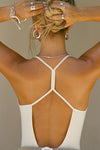 Back view of model posing in the fitted chalk modal Open T-Back Cami with an open t-back design