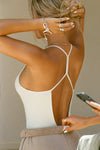 Back view of model posing in the fitted chalk modal Open T-Back Cami with an open t-back design