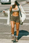 Full body front view of model walking in the fitted, soft army luxe knit Foldover Short with a foldover waist band that can be worn high, low or mid-rise