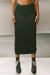 Front view of model from the waist down posing in the fitted black model Foldover Maxi Skirt with an adjustable fold over waistband
