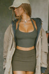 Front view of model posing in the cropped and fitted mineral flexrib Halter Crop Tank with a banded scoop neckline.