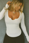 front facing image of the model wearing the Henley Long Sleeve in Bone Rib with her hand in her hair