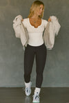 Full body front view of model posing in the fitted bone rib Henley Long Sleeve with a notch in the scoop neckline