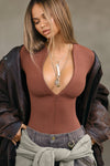 Front view of model posing in the form fitting oxblood flexrib Invisible Zip Long Sleeve top with a 3/4 front invisible zipper and a crew neckline