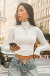 Front view of model posing in the form fitting stretchy bone rib Classic Turtleneck long sleeve top