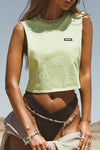  Front view of model posing in the relaxed fit melon cotton Cut Off Boyfriend Tank with low cut armholes, a crew neckline and a joah brown logo patch at the upper left chest
