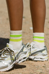 Side view of model in the crew style ribbed soft neon green yellow Mini Stripe Sock