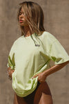 Front view of model posing in the relaxed fit melon cotton Oversized Crew Tee with a crew neckline and joah brown logo patch on the upper left side