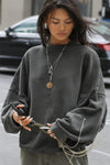 Front view of model posing in the relaxed fit washed black french terry Oversized Crew Pullover sweatshirt with dropped sleeves and a ribbed crew neckline