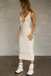 Full body side view of model posing in the sleeveless dune flexrib Plunge Tie Midi Dress with a plunging neckline and tie detail at the bust