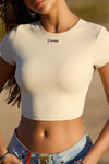 Close up front view of model posing in the cropped and fitted sueded yuma Second Skin Tee with JOAH BROWN logo patch on the front beneath the crew neckline