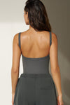 Back view of model posing in the fitted and stretchy smoke flexrib Low Back Scoop Tank with a u-neckline, thin straps and a  low scoop back.