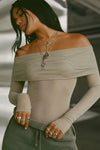 Front view of model posing in the fitted dew mesh Off The Shoulder Long Sleeve top with a folded off-the-shoulder neckline and thumbholes in the sleeves