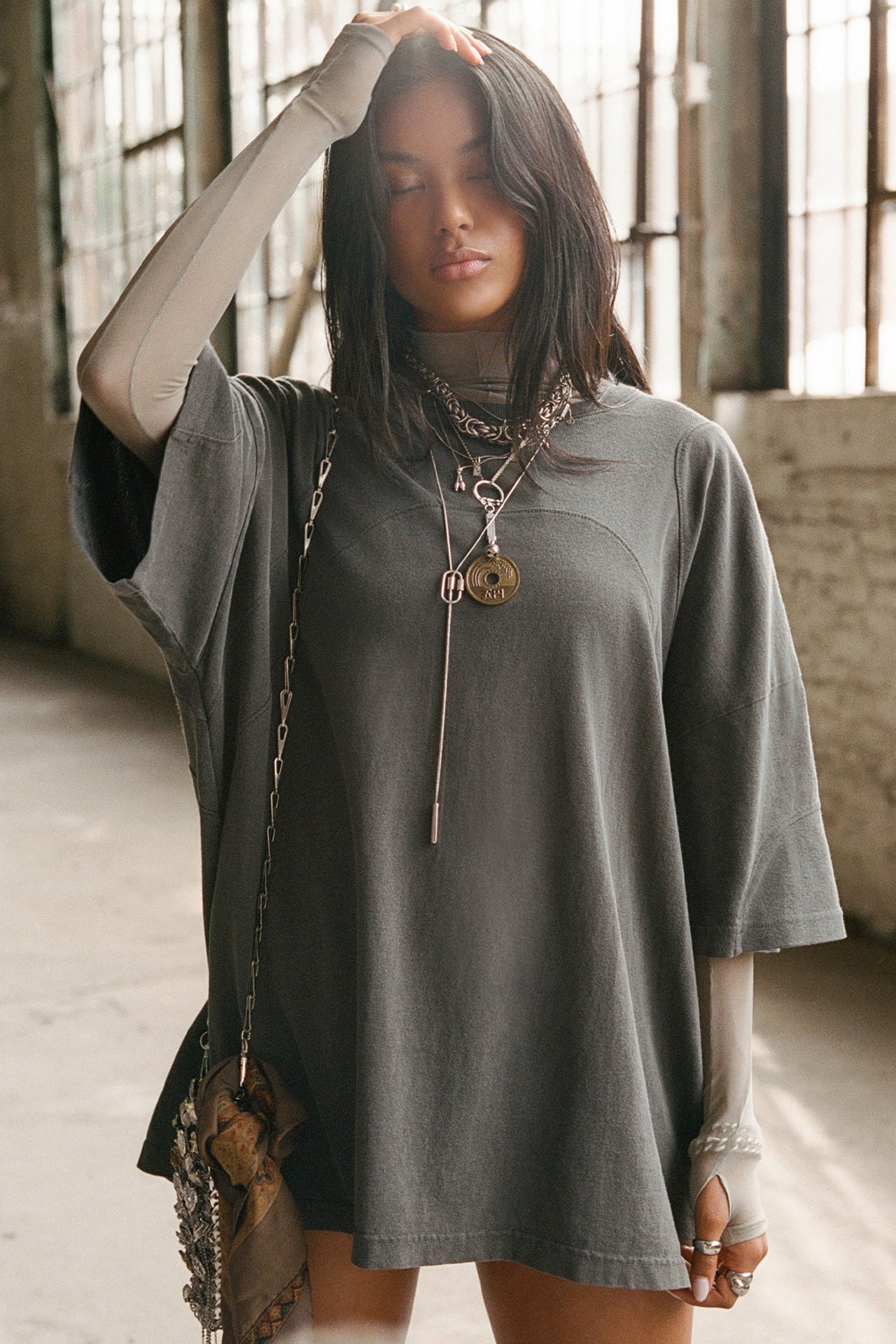 Front view of model posing in the oversized washed black cotton Original Graphic Tee with panel details 