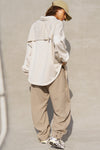 Full body back view of model posing in the relaxed fit ivory sherpa Oversized Button Down shirt jacket with a classic collar, front button closures and contrasting fabric details.