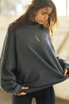 Front view of model posing in the relaxed fit washed black french terry Oversized Crew Pullover sweatshirt with dropped sleeves and a ribbed crew neckline