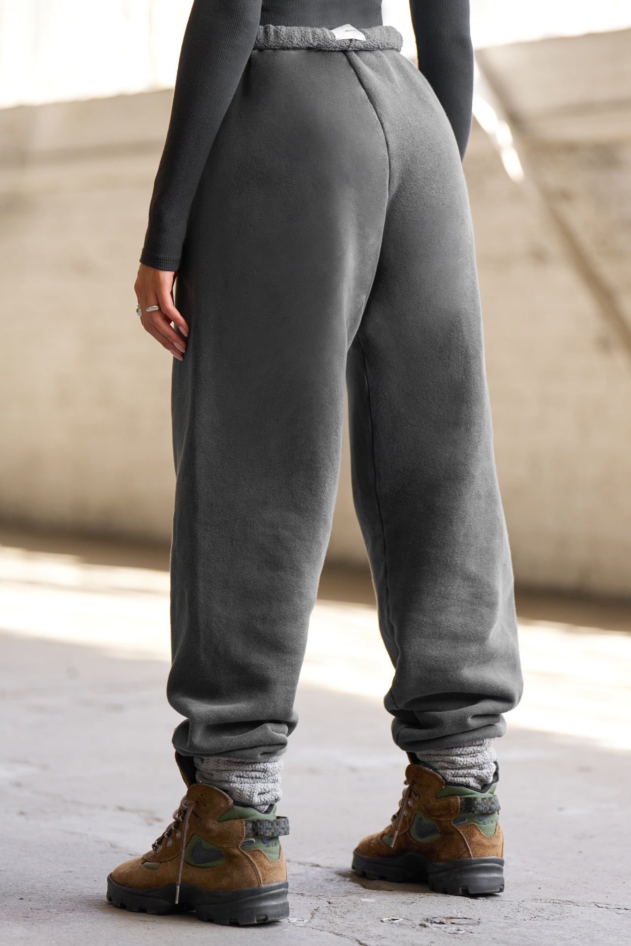 Back view of model from the waist down wearing the oversized loose fit washed black french terry Oversized Jogger with an elastic waistband and ankle cuffs