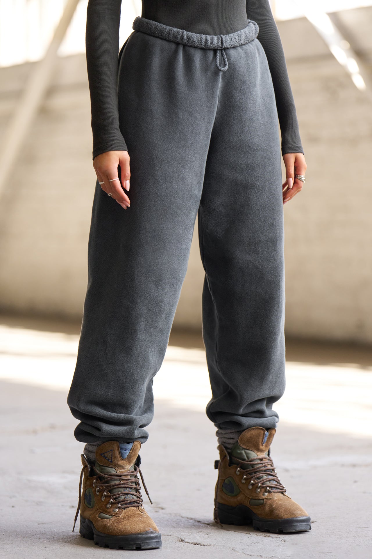 Front view of model from the waist down wearing the oversized loose fit washed black french terry Oversized Jogger with an elastic waistband and ankle cuffs