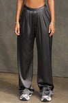 Front view of model from the waist down posing in the soft and smooth classic pleated iron silk Relaxed Silk Trouser with a flattering wide leg, zip fly and side pockets.