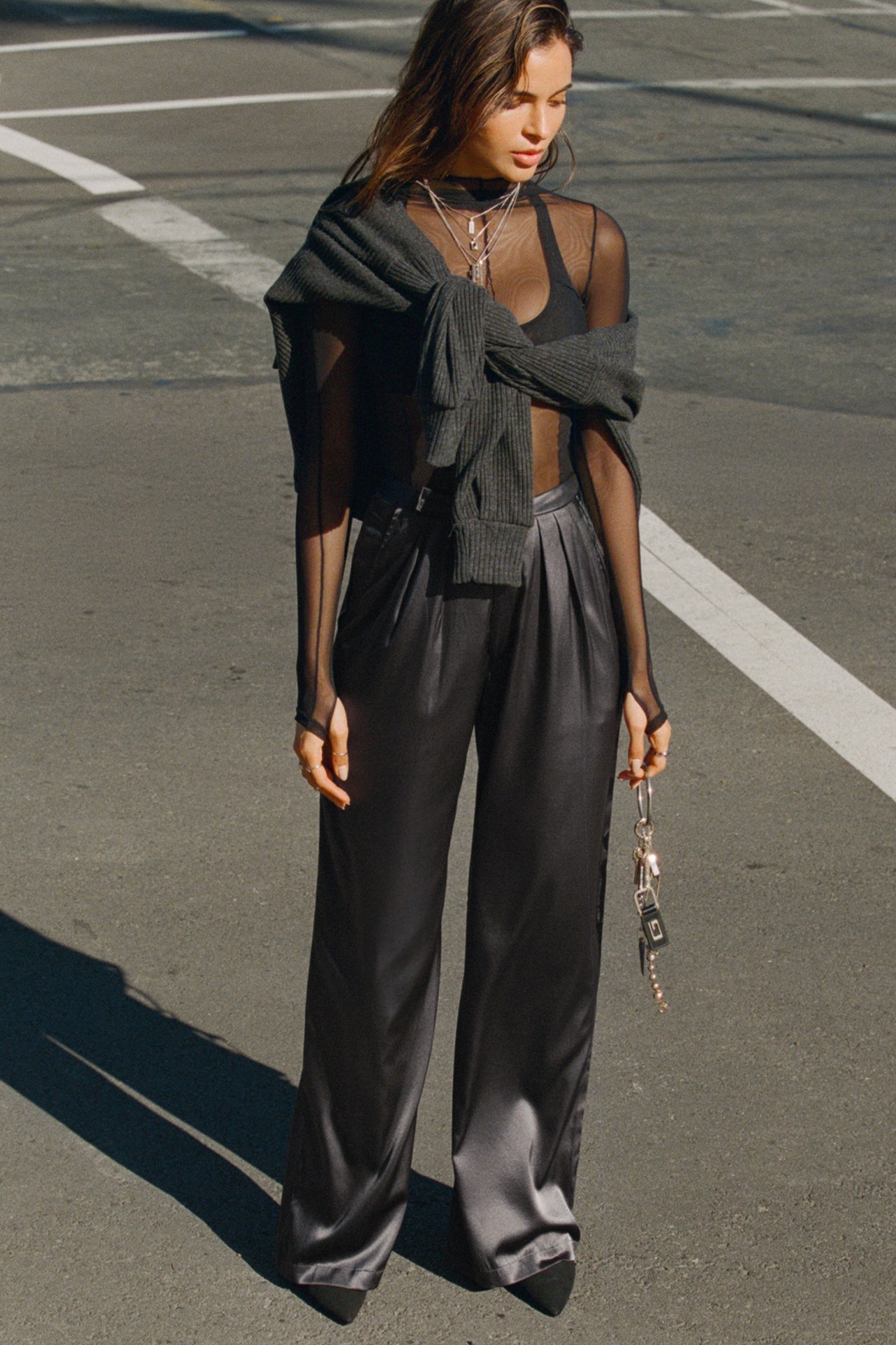 Full body front view of model walking in the street in the soft and smooth classic pleated iron silk Relaxed Silk Trouser with a flattering wide leg, zip fly and side pockets.