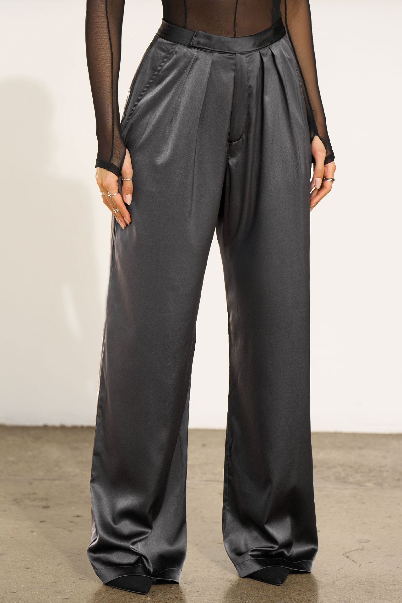 Front view of model from the waist down posing in the soft and smooth classic pleated iron silk Relaxed Silk Trouser with a flattering wide leg, zip fly and side pockets.