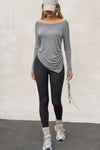 Full body front view of model posing in soft and lightweight shadow modal Ruched Asymmetrical Long Sleeve top with fitted sleeves, a relaxed asymmetrical hemline and a flattering ruched side detail.