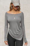 Front view of model posing in soft and lightweight shadow modal Ruched Asymmetrical Long Sleeve top with fitted sleeves, a relaxed asymmetrical hemline and a flattering ruched side detail.