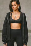 Front view of model posing in the sheer black mesh Scoop Neck Racerback Bra with a scoop neckline