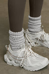 Close up side view of model wearing the  slouchy salt Scrunch Sock with extra long ribbed cuffs