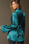 Back view of model posing in the smooth and soft lagoon Silk Wrap Blazer top with an adjustable tie waist and shawl collar neckline.