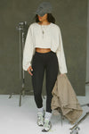 Full body front view of model posing in the cropped relaxed fit fog cotton slouchy crop long sleeve top with a crew neckline, dropped shoulders and oversized sleeves