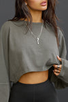 Close up front view of model posing in the cropped relaxed fit haze cotton Slouchy Crop Lonng Sleeve top with a crew neckline, dropped shoulders and oversized sleeves