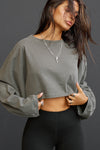 Front view of model posing in the cropped relaxed fit haze cotton Slouchy Crop Lonng Sleeve top with a crew neckline, dropped shoulders and oversized sleeves