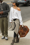 Full body front view of model posing outside in the street wearing the oversized pearl grey french terry Slouchy Pullover Sweatshirt with a wide, off-the-shoulder neckline and a JOAH BROWN logo patch on the right sleeve