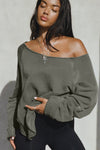 Front view of model posing in the oversized washed sage french terry Slouchy Pullover Sweatshirt with a wide, off-the-shoulder neckline and a JOAH BROWN logo patch on the right sleeve