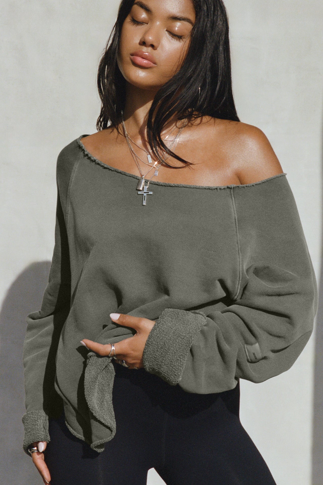 Front view of model posing in the oversized washed sage french terry Slouchy Pullover Sweatshirt with a wide, off-the-shoulder neckline and a JOAH BROWN logo patch on the right sleeve