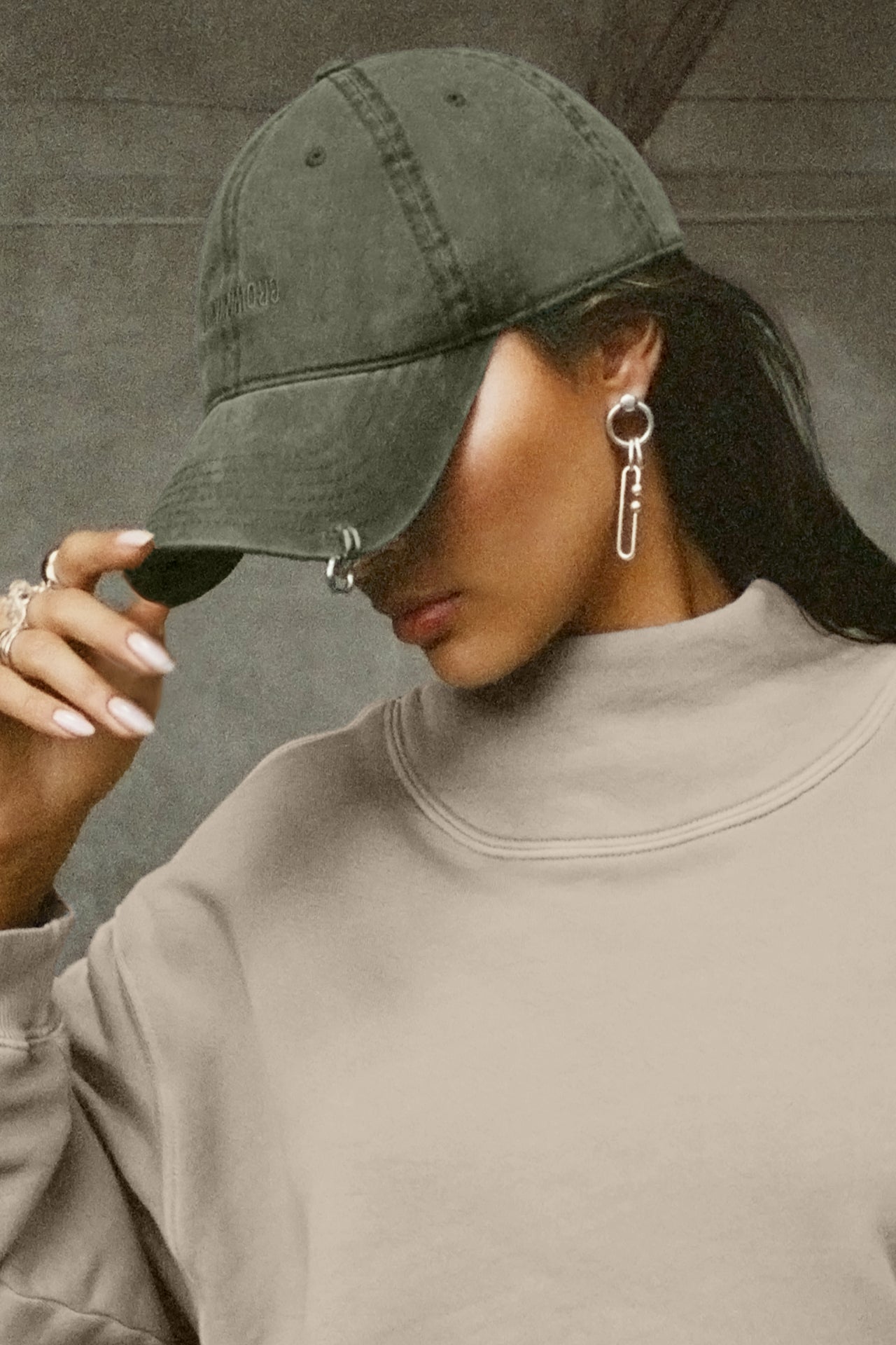 Side view of model wearing the six-panel washed green Official Cap with a curved brim and an embroidered upside down Joah Brown logo on the front