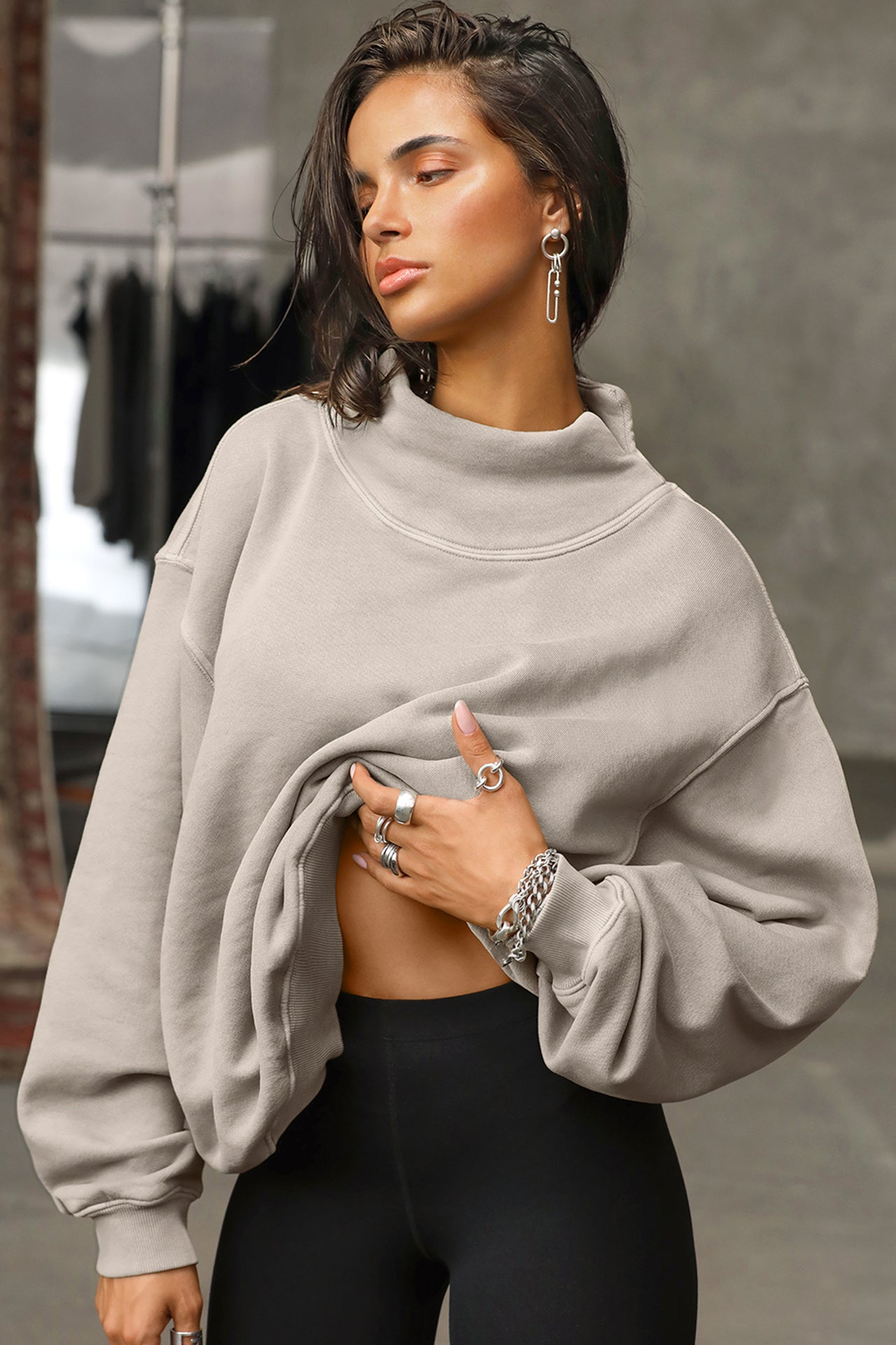 Front view of model posing in the comfortable sand french terry Turtleneck Sweatshirt pullover with a side split in the collar and a slightly oversized fit