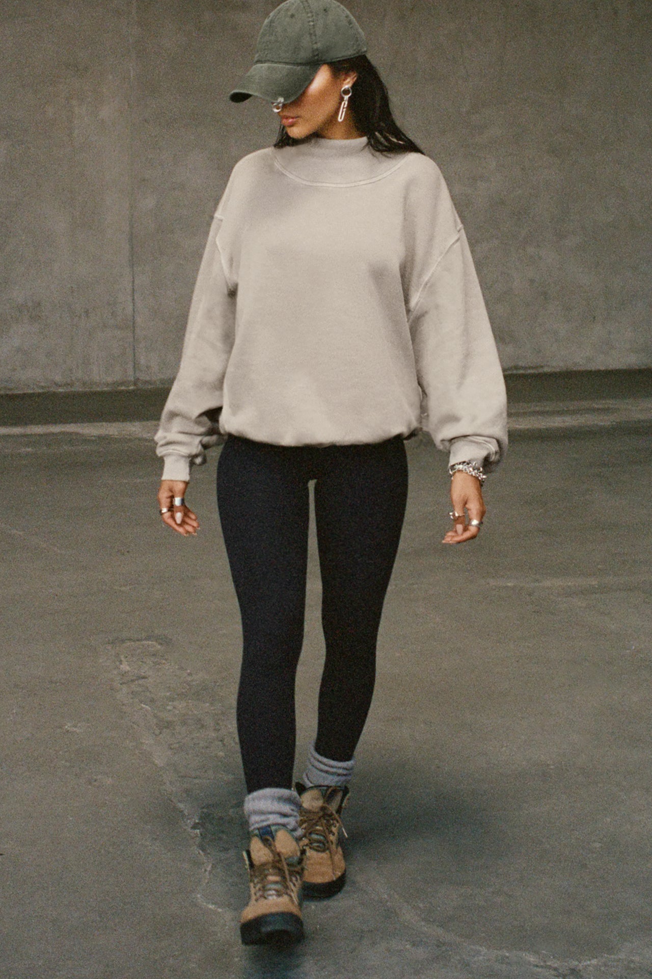 Full body front view of model posing in the comfortable sand french terry Turtleneck Sweatshirt pullover with a side split in the collar and a slightly oversized fit